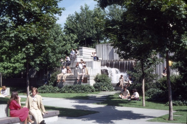 color photo of people standing and sitting around a fountain in Freeway Park