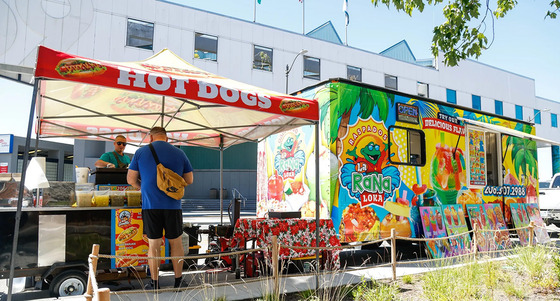 People ordering from food trucks and sitting down to eat by the Waterfront
