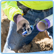 Person priming PVC pipe for an installation