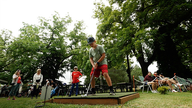 A youth plays golf at Woodland Park.