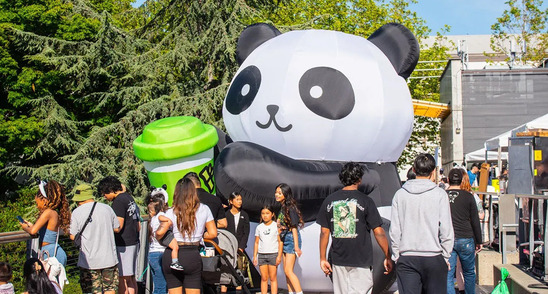 People taking pictures in front of a giant inflatable panda bear at PandaFest