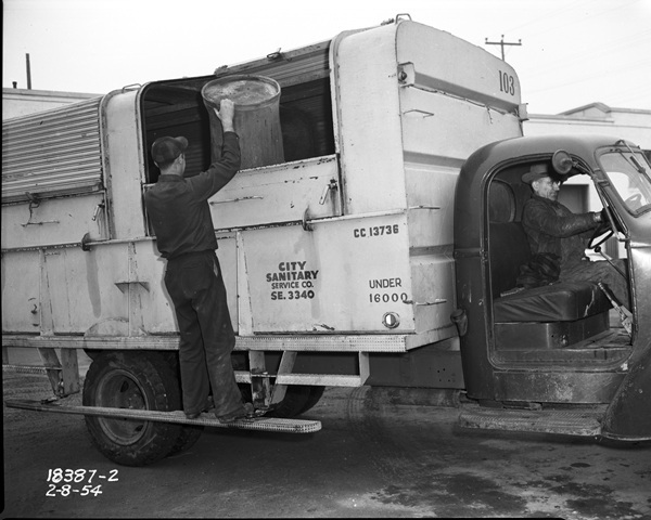 Black and white photo of garbage truck and workers
