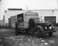 black and white photo of garbage truck and workers, 1954