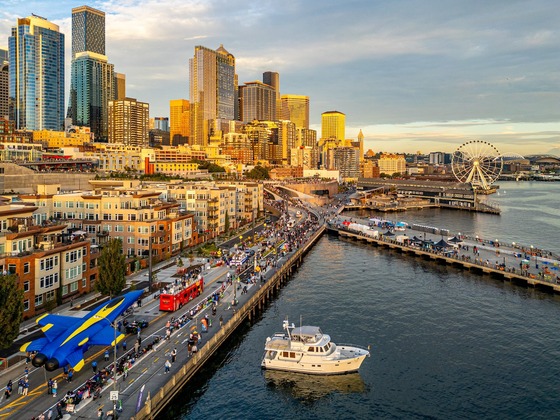 An overhead view of a packed parade in downtown Seattle with the Ferris wheel and waterfront visible
