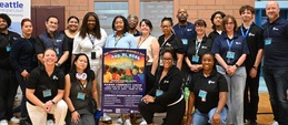 Group picture of Seattle municipal court staff surrounding 2026 event poster at Rainier Community Center