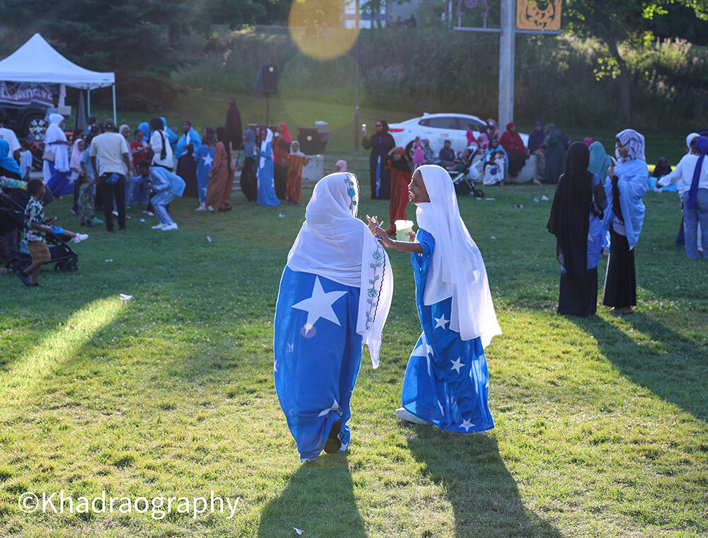 Two young Somali girls, dressed in the flag, have an animated conversation