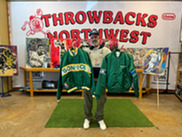 Owner of Throwbacks NW holding vintage sports gear