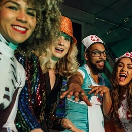 Four people smiling and wearing Halloween costumes