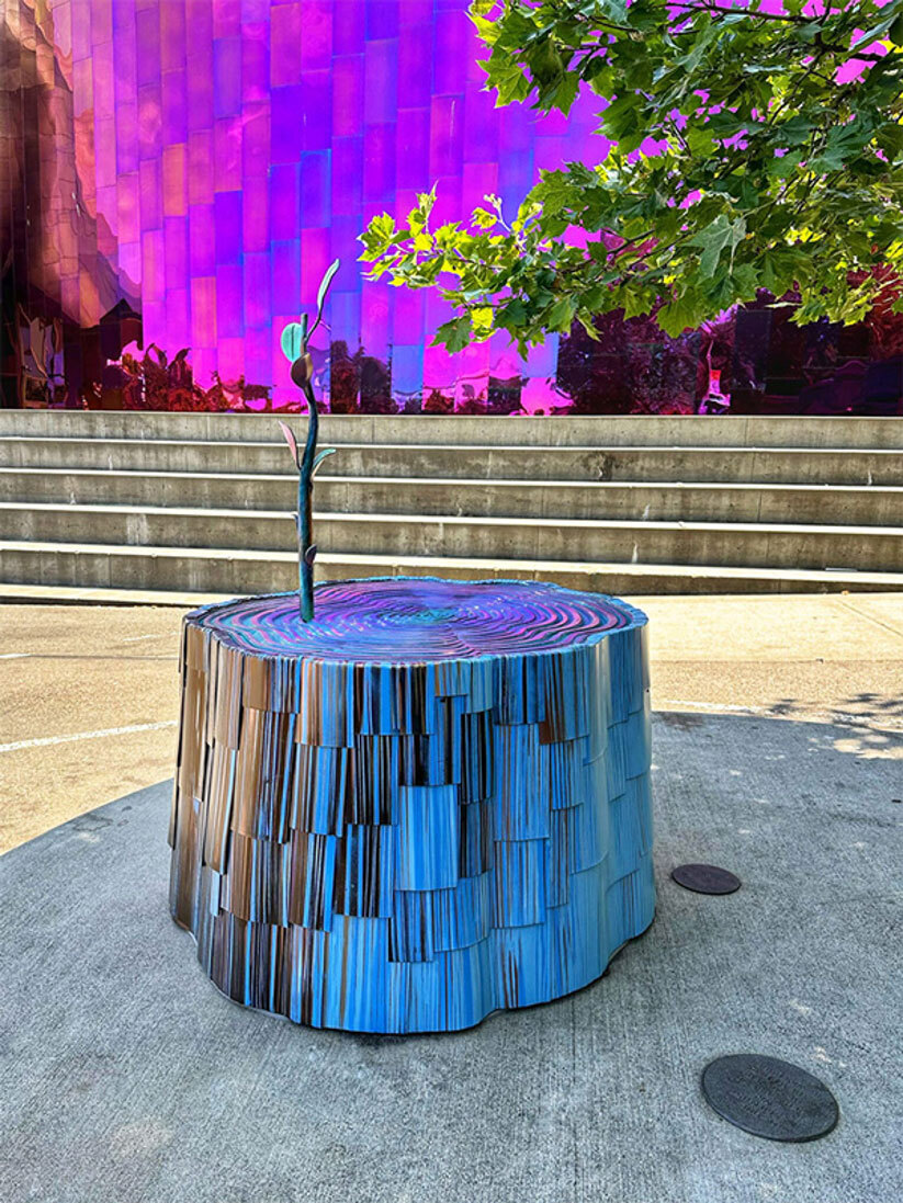 Colorful tree stump with a shoot growing out of the top.