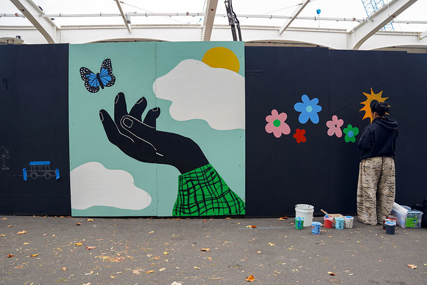 Mural of an open hand with a butterfly nearby.