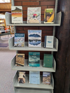 A bookshelf full of lake- and water-themed books for adults.