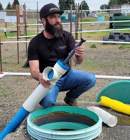 Septic professional Jeremiah Gunia showing off parts of a septic system.