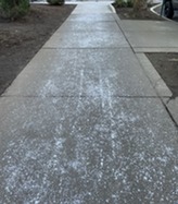 Too much road salt scattered across a sidewalk.