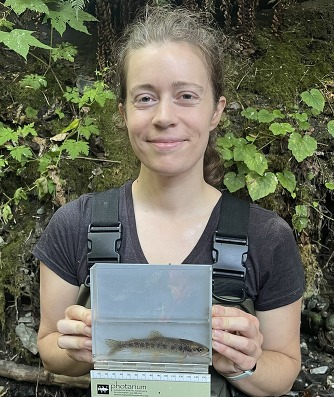 Source Control Inspector Halee Sexton holding a fish in a fish viewer during her internship.
