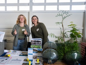 Anna and Leanne of Skagit NRD behind a table with displays and info about clean water, photo from Holboy Entertainment