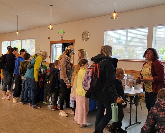 Skagit County staff being swarmed by children while talking to them about water quality issues.