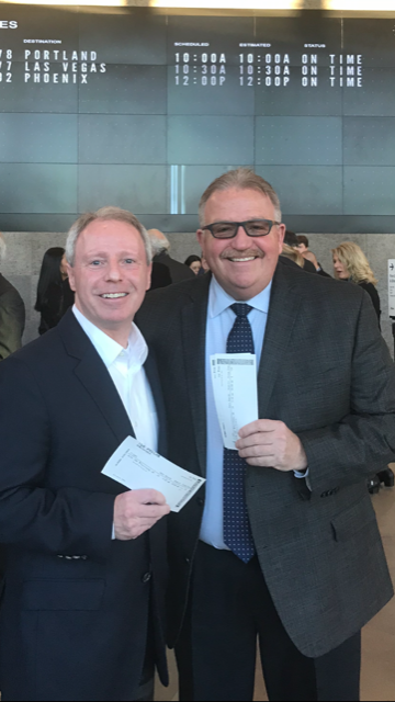 Photo of Terry Ryan and Sheriff Trenary holding boarding passes