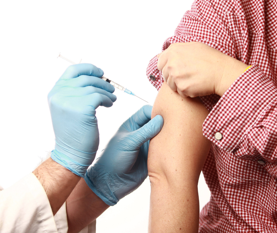 person receiving flu shot in the arm from gloved person