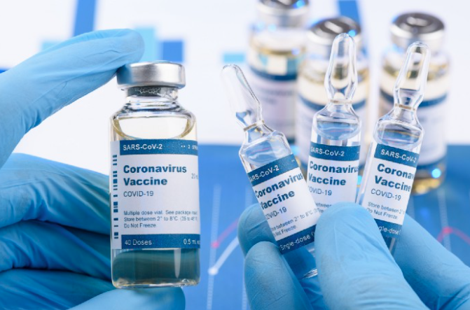 Photo coronavirus vaccine held in hands covered with blue exam gloves