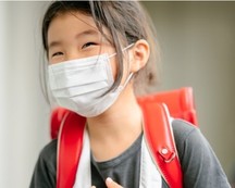 Young girl wearing mask and back pack