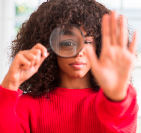 Woman with magnifying glass gesturing to stop misinformation