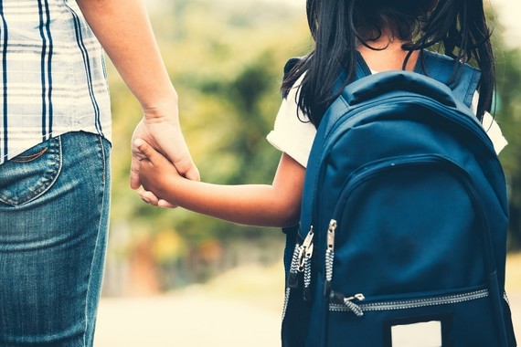 Parent and child holding hands on the way to school
