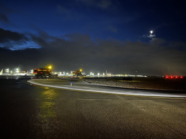 Snow removal equipment clears the main runway on Feb. 14, 2023