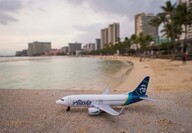 A miniature 737 with Alaska Airlines branding on a beach in Honolulu