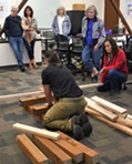 Instructor demonstrating cribbing using stacked lumber