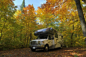 Image of and RV parked in fall trees. 