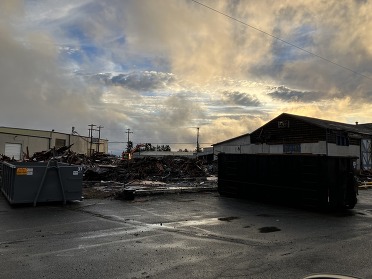 A large pile of building debris is sorted for recycling