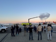 ARFF truck sprays water in the air with Pack 95 scouts and parents watching