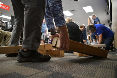 Students practice cribbing rescue techniques using lumber