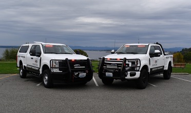 Two white Snohomish County Emergency Management trucks.