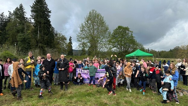 Group of children and adults posed for photo at tree planting event