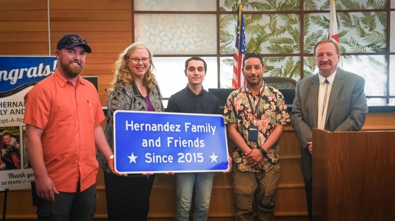 Adopt-A-Road volunteers pose with new road sign