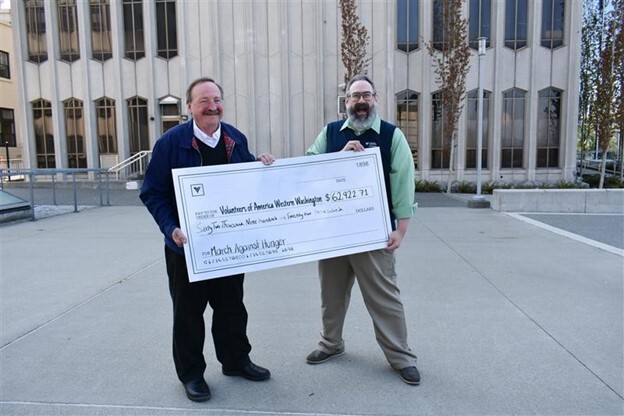 Executive Somers hands giant check to Volunteers of America representative for March Against Hunger fundraiser
