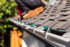 Image of a roof with Holiday Lights on it- held on by gutter clips