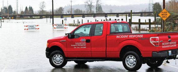 A DEM Truck Parked In Front of a Flooded Roadway