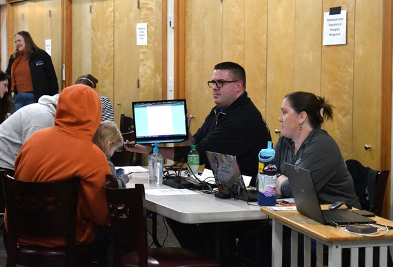 Snohomish County Emergency Management staff help a family at the Disaster Assistance Center in Sultan on Jan. 11