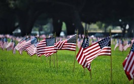 American flags in grass of the grounds of a memorial sight celebrating Memorial Day