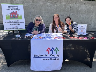 Snohomish County Senior Housing Human Services Team with information on affordable housing for seniors and displaying pride swag