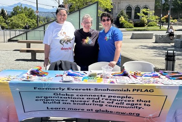 GLOBE table at the Pride Resource Fair with three representatives from organization