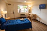 A new room at the Everett New Start Center including a desk, bed, sidetables, AC, and a TV.