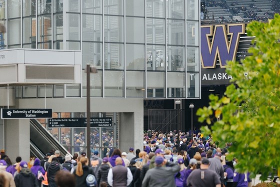 Fans exit the light rail station at Husky Stadium for a game.