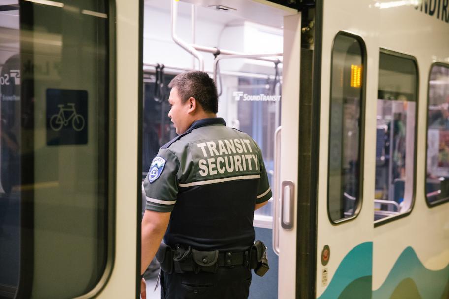 A transit security officer looks inside a Link car.