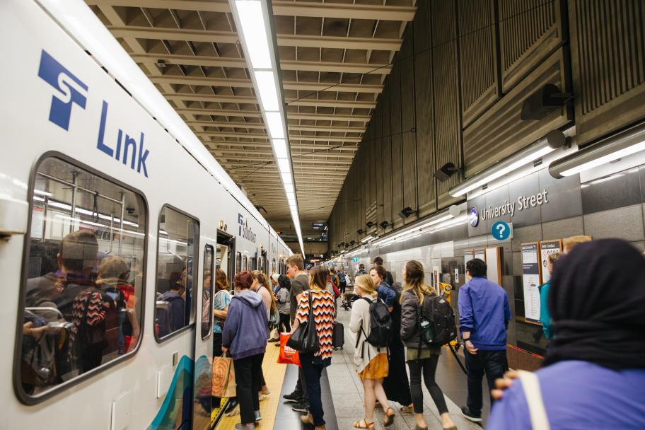 A crowd boards a light rail train at University Street Station in downtown Seattle.