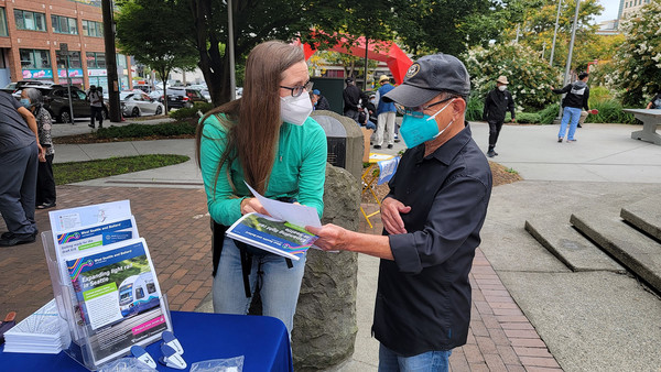 Photo of Sound Transit employee sharing information with a rider, West Seattle and Ballard Link Extensions
