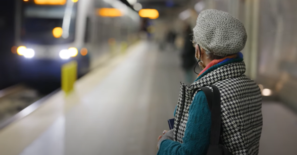 Person watching a Link light rail train arrive at a station
