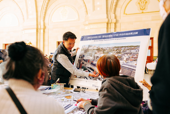 Photo of people around a table viewing information